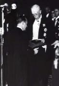 Gustavo V di Svezia consegna a Fermi il diploma e la medaglia del Nobel.